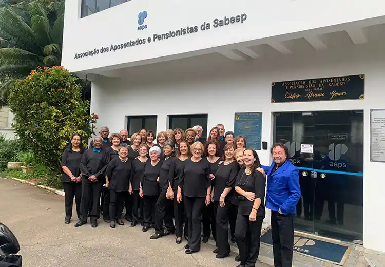 Maestro e componentes do Coral Canto das Águas em frente ao Prédio da AAPS